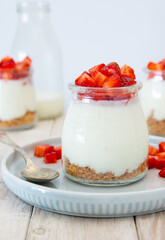 YOGURT MOUSSE IN JAR WITH FRESH STRAWBERRIES ON WHITE BACKGROUND