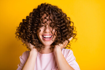 Photo portrait of girl with curly hairstyle wearing t-shirt laughing touching hair isolated on...