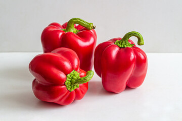 Ripe red bell peppers on a white table