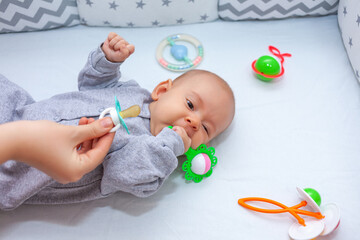 mom gives pacifier to newborn daughter