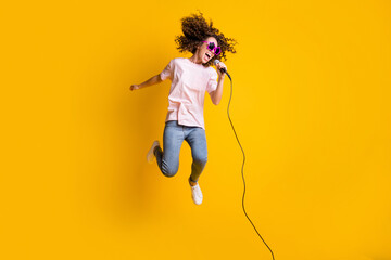 Photo portrait full body view of girl jumping up singing into mic isolated on vivid yellow colored...