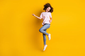 Photo portrait full body view of girl jumping up playing on imaginary guitar isolated on vivid yellow colored background