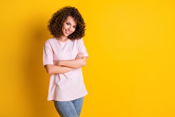 Photo of young curly brown hair girl confident smile attractive crossed hands isolated over yellow color background