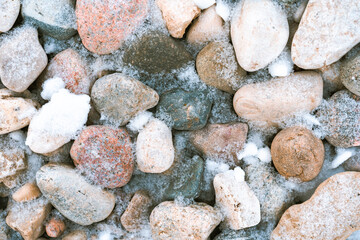 Beach stones covered with snow, background