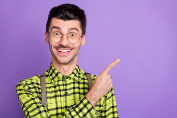 Fototapeta premium Portrait of young happy excited smiling positive gentleman point finger copyspace isolated on violet color background