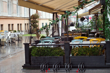 Rainy weather and wet dining tables on the outdoor terrace of cafe in Novi Sad, Serbia