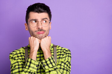 Obraz premium Photo portrait of bored guy holding head with fists looking at blank space isolated on vivid violet colored background