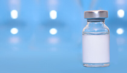 Vial with a vaccine on a blue background. Coronavirus vaccine.Сopy space.