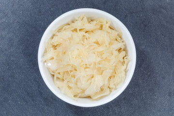 Sauerkraut coleslaw cabbage sliced from above bowl on a slate
