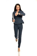 Young shocked business woman looking in her wristwatch and run