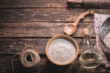 A flour in the jar and old different kitchen utensils on the table background.