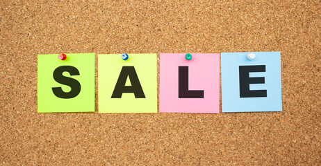 Color notes with letters pinned on a board. Word SALE.