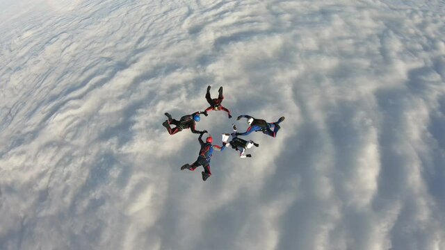Skydiving. Team jump. Skydivers are doing figures in the sky.