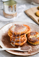 Sweet cottage cheese pancakes. Condensed milk. Festive sweet breakfast or lunch. Light background. Close up