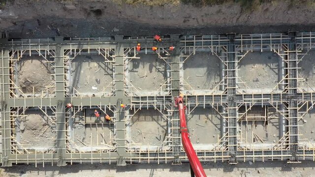 The workers are pouring the foundation. Bird's eye view.