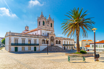 Sanctuary of Our Lady of Nazare catholic church in cobblestone square with palm trees in Sitio...