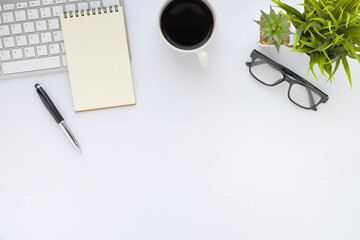 White office desk table with keyboard, notebook and coffee cup with equipment other office supplies. Business and finance concept. Workplace, Flat lay with blank copy space. Top view