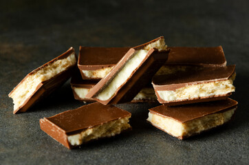 Closeup of pile of tasty sweet chocolota with cookies on the dark rey table