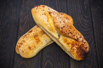 Two baked loaves of Ukrainian national bread on black antique table