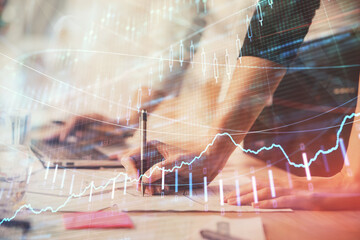 Multi exposure of woman hands typing on computer and financial chart hologram drawing. Stock market...
