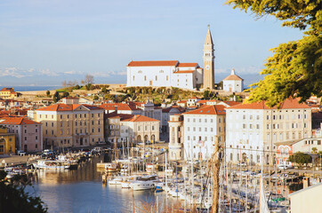 Red roofs of the historical center of old town Piran with main church against the sunset sky and...