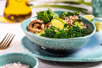 Diet salad made from fresh vegetables broccoli, mushrooms, spinach and quinoa in a bowl. Delicious breakfast or snack, Clean eating, dieting, vegan food concept. vertical image.