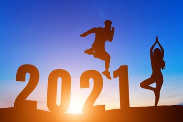 Happy New Year Numbers 2021, Silhouette a man handsome jumping feels happy moving  and woman practicing yoga early morning sunrise over the horizon background, Health and Happy new year concept.