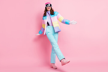 Full length photo of cute lady snowboarder wear colorful coat eyewear walking dancing isolated pink...