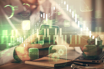Fototapeta premium Double exposure of man's hands holding and using a phone and financial graph drawing. Analysis concept.