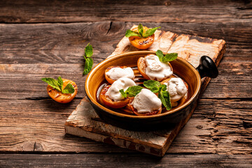 Delicious grilled peaches served with whipped cream and mint leaves. Grilled peaches, apricots, nectarines and ice cream