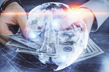 Fototapeta na wymiar Multi exposure of financial theme drawing hologram and USA dollars bills and man hands. Business concept.