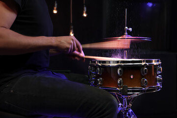 Drummer playing snare drum with sticks close up.