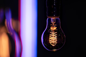 Close up of a burning lamp on a blurred dark background.