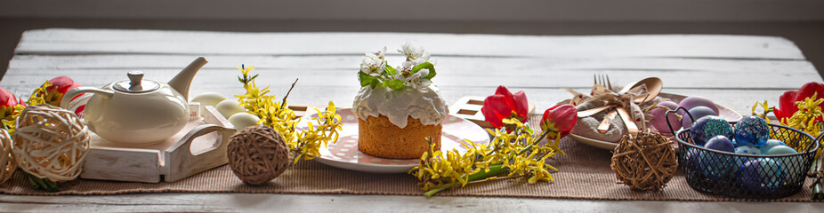 Easter composition with cake, tea, flowers, eggs and decoration details.