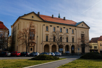 Fototapeta premium Piarist dormitory now Homeland Museum and library in sunny day, Main square with colorful buildings of historic medieval royal town Slany, Central Bohemia, Czech Republic