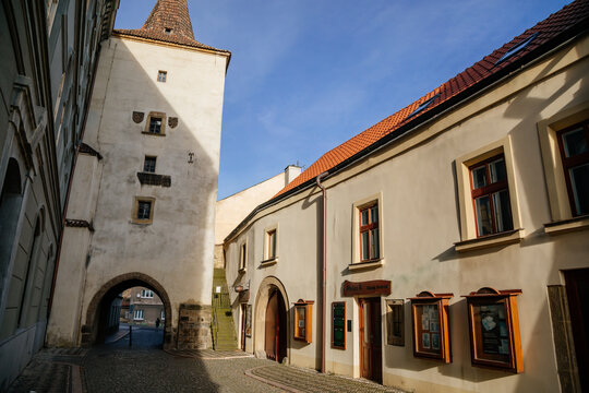 Gothic tower of the Velvary Gate, town fortifications built in the pre-Hussite period in sunny day, street of historic medieval city Slany, Central Bohemia, Czech Republic