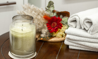 Composition with jar candlestick and bath towels close up.