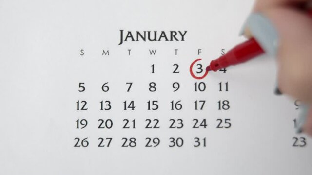 Female hand circle day in calendar date with a red marker. Business Basics Wall Calendar Planner and Organizer. JANUARY 3th