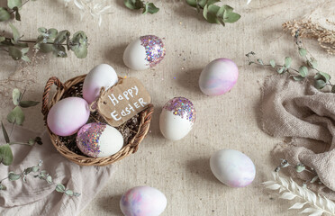 Easter composition with decorative eggs in a basket on sackcloth.