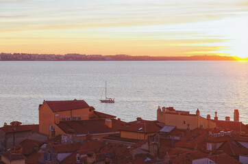 Red roofs of the historical center of old town Piran against the sunset sky and Adriatic sea,...