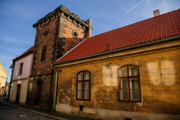 Fototapeta premium Narrow picturesque street with colorful buildings in old historic center in medieval city Slany, yellow renaissance house with stone tower, Central Bohemia, Czech Republic