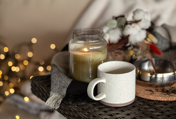 Cozy home composition with a cup of coffee and a candle in a candlestick.