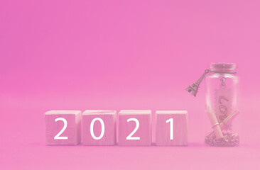 Valentine 2021 , 2021 on Wooden block on pink background with love inside glass bottle and copy space . Love celebration postcard concept 