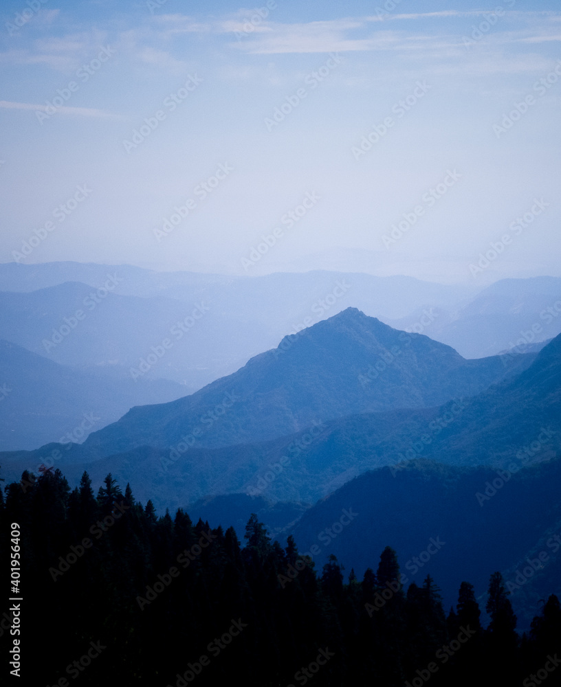 Wall mural beautiful landscape of blue mountains layers with clouds