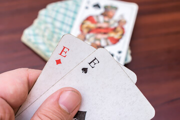 Man holding aces and trumps in his hands in a card game