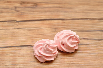 Two pink meringues on a table
