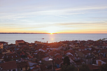 Red roofs of the historical center of old town Piran against the sunset sky and Adriatic sea, aerial view, Slovenia