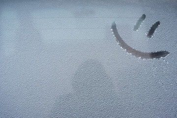 Drawing emoticon on a snowy car window