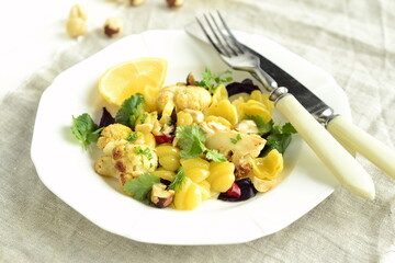 Corn pasta with cauliflower, hazelnuts and herbs