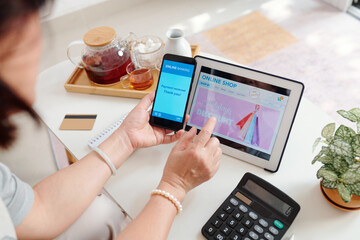 Woman shopping online and paying for purchases with banking application on smartphone